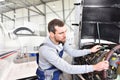 Aircraft mechanic repairs an aircraft engine in an airport hangar Royalty Free Stock Photo