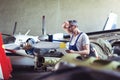 Aircraft mechanic repairs an aircraft engine in an airport hangar Royalty Free Stock Photo