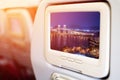 Monitor in front of passenger seat showing Bridge in Macau view at night