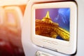 Monitor in front of passenger seat showing Eiffel Tower with strom sky at late evening, Paris, France