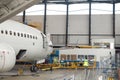 Aircraft. Passenger airplane under heavy maintenance in airport hangar indoors in the daytime Royalty Free Stock Photo