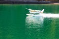 Aircraft seaplane taking off on calm water of lake Royalty Free Stock Photo