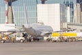 Aircraft for service, loading food, refueling fuel tanks before the flight at the airport terminal building. Back view Royalty Free Stock Photo