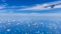 Aircraft wing flying over the blue clouds