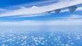 Aircraft wing flying over the blue clouds