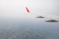 Aircraft wing flying view from window of city in the morning. Tr