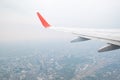 Aircraft wing flying view from window of city in the morning. Tr