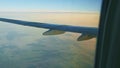 Airial view on airplane wing from window with green land and white clouds