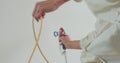 Airless spray painting. Close-up of professional painter paints the walls with paint spray gun. Royalty Free Stock Photo