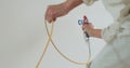 Airless spray painting. Close-up of professional painter paints the walls with paint spray gun. Royalty Free Stock Photo