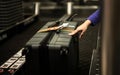 An airline employee is loading suitcases on a baggage delivery conveyor belt at Suvarnabhumi International Airport