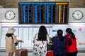 Airline passengers look at airplanes departure information panel at Hong Kong International Airport