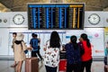 Airline passengers look at airplanes departure information panel at Hong Kong International Airport
