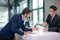 Airline staff give boarding pass to the passenger business man and explain about the detail at counter service in the airport Royalty Free Stock Photo