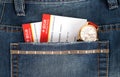 Airline ticket and watch in jeans pocket