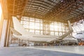 Airliner aircraft in a hangar with an open gate to the service. Royalty Free Stock Photo