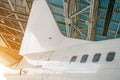 Airliner aircraft in a hangar with an open gate to the service. Royalty Free Stock Photo