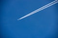 Airliner with Contrails Flying in a Clear Blue Sky Royalty Free Stock Photo
