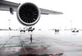 Airliner jet wing and engine on airport apron on rainy day Royalty Free Stock Photo