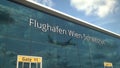 Commercial plane landing reflecting in the windows with Flughafen Wien Schwechat or Vienna Airport text