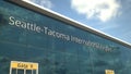 Commercial plane take off reflecting in the windows with Seattle-Tacoma International Airport text, 3d rendering