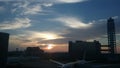 Airliners waiting to depart against an evening sunset.