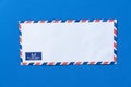 Airmail envelope on blue background Royalty Free Stock Photo