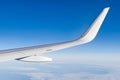 Airplain wing view thrue window in the sky. Clouds sky, airplane's wing through porthole of aircraft Royalty Free Stock Photo