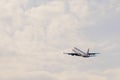 An airplan goes towards the clouds at sunset after take off