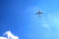 Airplan leaves a trail in the blue sky . Airliner is takking off. White cloud in the blue sky in which the plane flies. Royalty Free Stock Photo