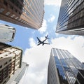 Airplane Passenger plane / aircraft flying over and between skyscrapers Royalty Free Stock Photo