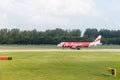 Airplane of AirAsia low-cost airline taxis in airport