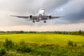 Airplane airplane approach landing above the green grass field at the airport. Royalty Free Stock Photo