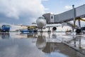 Airplane at the airport. Passengers board through a telescopic gangway. Loading luggage. Preparing for the flight Royalty Free Stock Photo