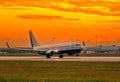 Airplane on airport runway under sunset view dramatic sky with evening light Royalty Free Stock Photo