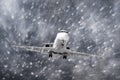 Airplane approaching on a landing in snowstorm bad weather. Royalty Free Stock Photo