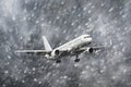 Airplane approaching on a landing in snowstorm bad weather. Royalty Free Stock Photo