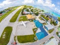 Airplane on apron of Tuvalu international airport, just arrived. Aerial view. Vaiaku village, Funafuti atoll, Polynesia, Oceania.