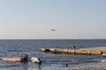 an airplane arriving to Santa Marta city viewed from a beach with a boat and a banana boat and shore in sunny sunset Royalty Free Stock Photo