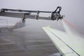 Airplane is being prepared for flight. The wing is sprayed by special liquid to prevent icing Royalty Free Stock Photo