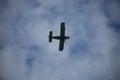 The airplane biplane type flies against the background of the cloudy sky. View of the bottom