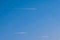 Airplane in a blue cloudless sky with colored colorful contrails without clouds during sunset and golden hour, Germany