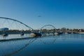 Airplane in the blue sky over Tempe Town Lake Pedestrian Bridge in Arizona. Royalty Free Stock Photo