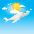 Airplane in blue sky with sun and clouds.