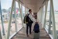 Casual male passenger carrying the hand luggage bag, walking the airplane boarding corridor. Royalty Free Stock Photo