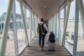 Casual male passenger carrying the hand luggage bag, walking the airplane boarding corridor. Royalty Free Stock Photo