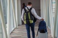 Casual male passenger carrying the hand luggage bag, walking the airplane boarding corridor. Royalty Free Stock Photo