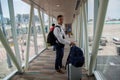 Airplane Boarding. Young male passenger carrying the hand luggage bag, walking the airplane boarding corridor.