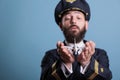Airplane captain in uniform holding plane model in palms