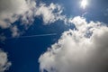 Airplane and clouds onder blue sky with sun Royalty Free Stock Photo